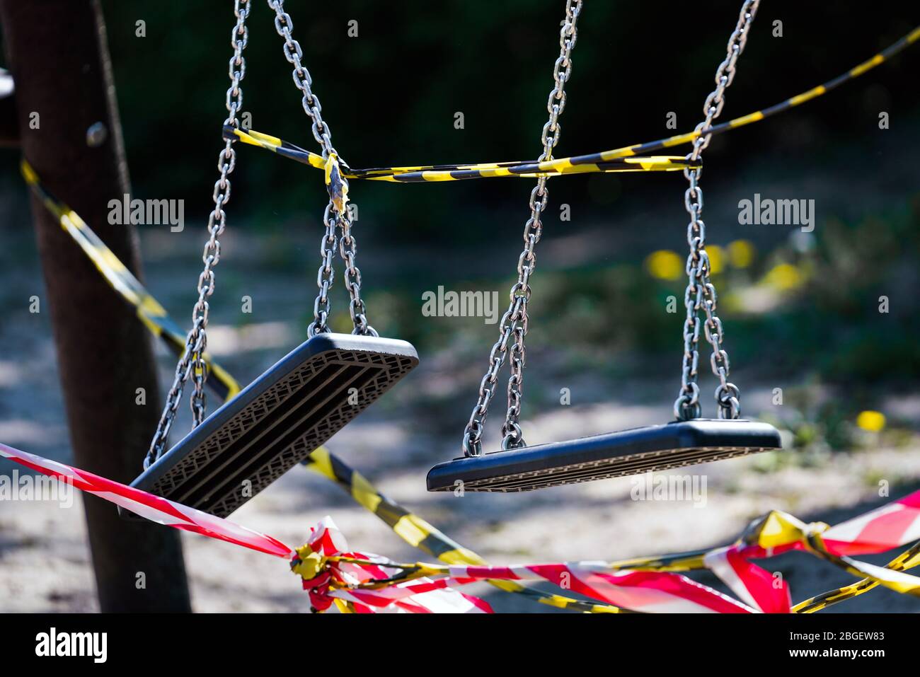 Dortmund, 21.4.2020: Mit Flatterband festgebundene Kinderschauen auf einem wegen der Coronavirus Krise (Covid-19, SARS-CoV-2) und zum Schutz vor Neuinfektionen gesperten Kinderspielplatz in einer Kleingartenanlage in Dortmund. --- Dortmund, 21. April 2020: Kinderschaukeln mit Bändern an einem Spielplatz in Dortmund gebunden. Geschlossen wegen der Coronavirus-Krise (Covid-19, SARS-CoV-2) und zum Schutz vor Neuinfektionen. Stockfoto