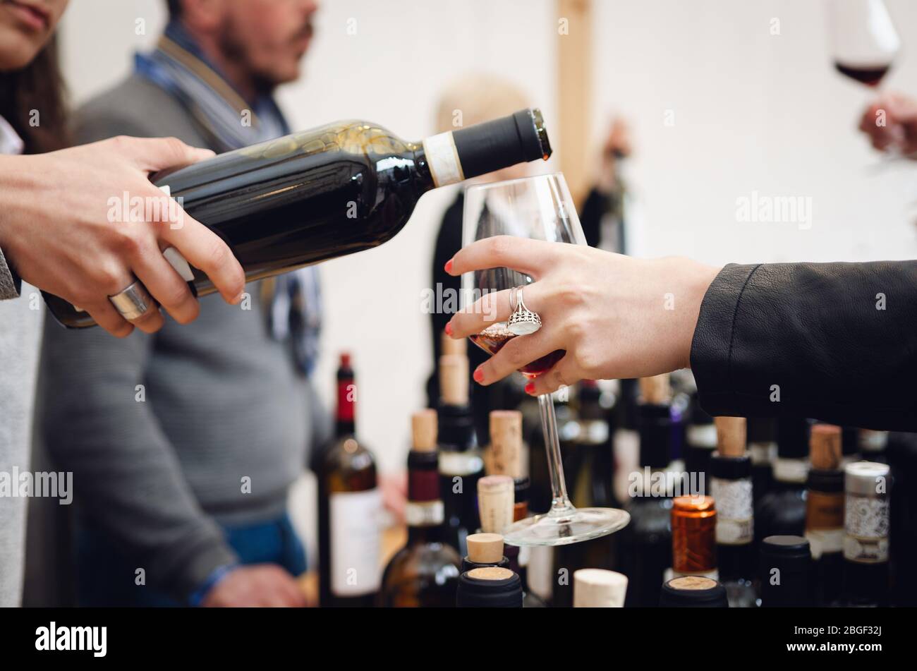 Verkostung mit einer Sommelierin, die ein Glas Barolo Rotwein in Alba (Piemont, Italien) serviert Stockfoto