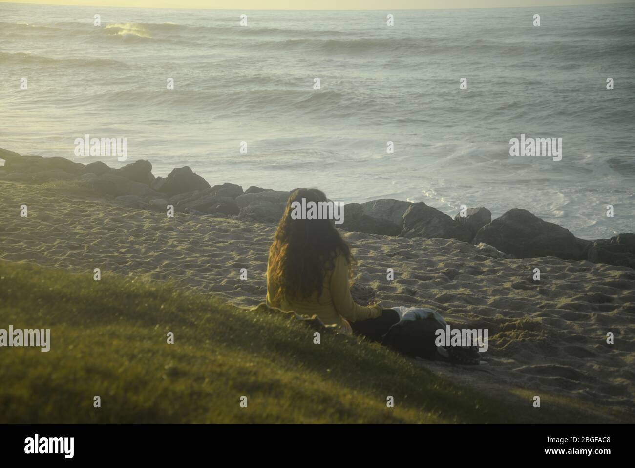 Junge Frau meditiert an einem Strand im Südwesten Frankreichs Stockfoto