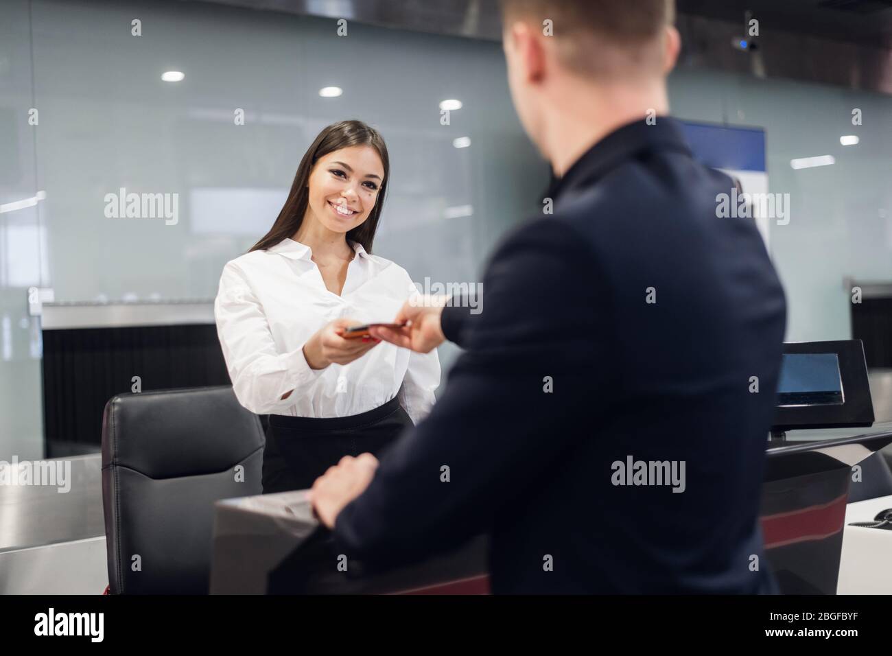 gut aussehend Geschäftsmann Übergabe Flugticket bei Airline Check-in Schalter Stockfoto