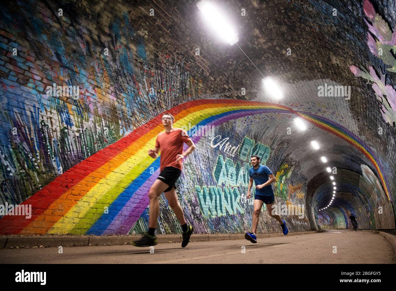 Menschen, die ihre tägliche Übung machen, gehen unter dem Regenbogengemälde im Colinton Tunnel, Edinburgh, während Großbritannien weiterhin in der Sperre bleibt, um die Ausbreitung des Coronavirus einzudämmen. Stockfoto