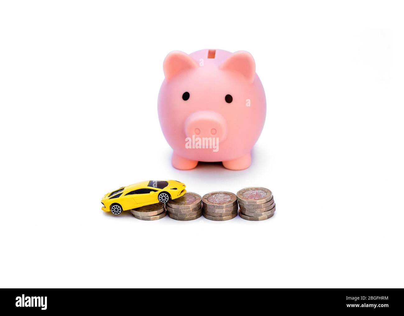 Rosa Sparschwein träumen von dem Auto mit Münzen / Geld und Das gelbe Auto vor ihnen isoliert gegen ein Weißer Hintergrund Stockfoto