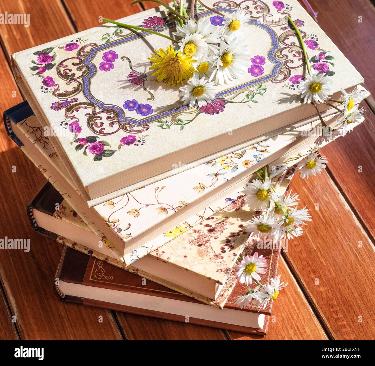 Bücher und Blumen auf dem Tisch im Garten Stockfoto