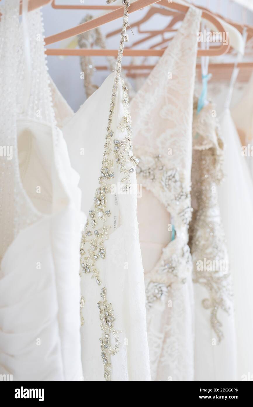 Hochzeitskleider hängen an einer Schiene. Stockfoto