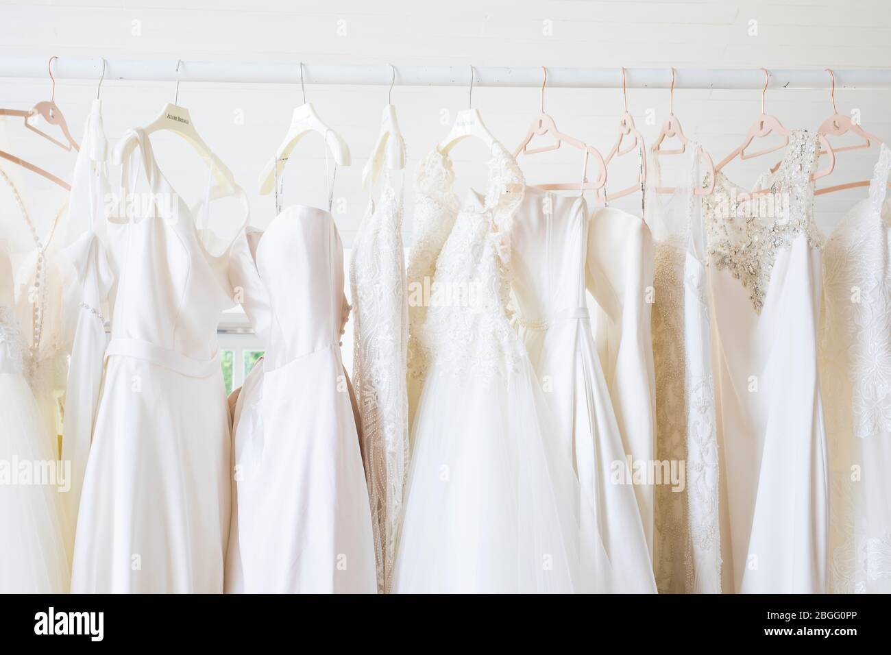 Hochzeitskleider hängen an einer Schiene. Stockfoto