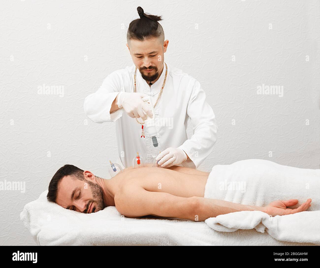 Traditionelle chinesische Medizin Arzt tun Massage mit Vakuumbechern, um männliche Patienten. Gesundheit Erholung Mann mit Vakuumsaugern. Stockfoto