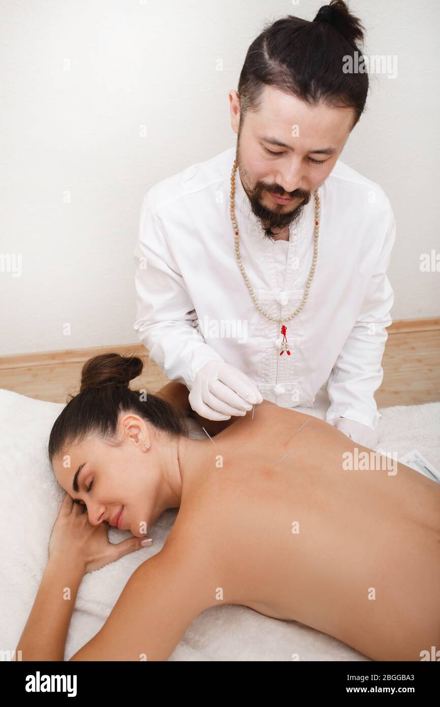 Reflexologe, der ein Akupunkturverfahren macht. Stressabbau mit Akupunktur. Traditionelle chinesische Medizin Stockfoto