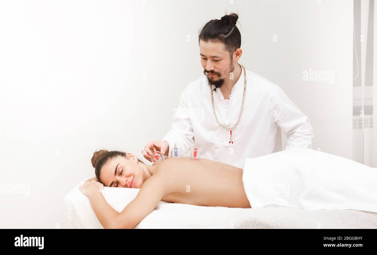 Traditionelle chinesische Medizin Arzt Massage mit Vakuumbechern zu einer weiblichen Patientin. Gesundheit Erholung Frau mit Vakuumbechern. Stockfoto