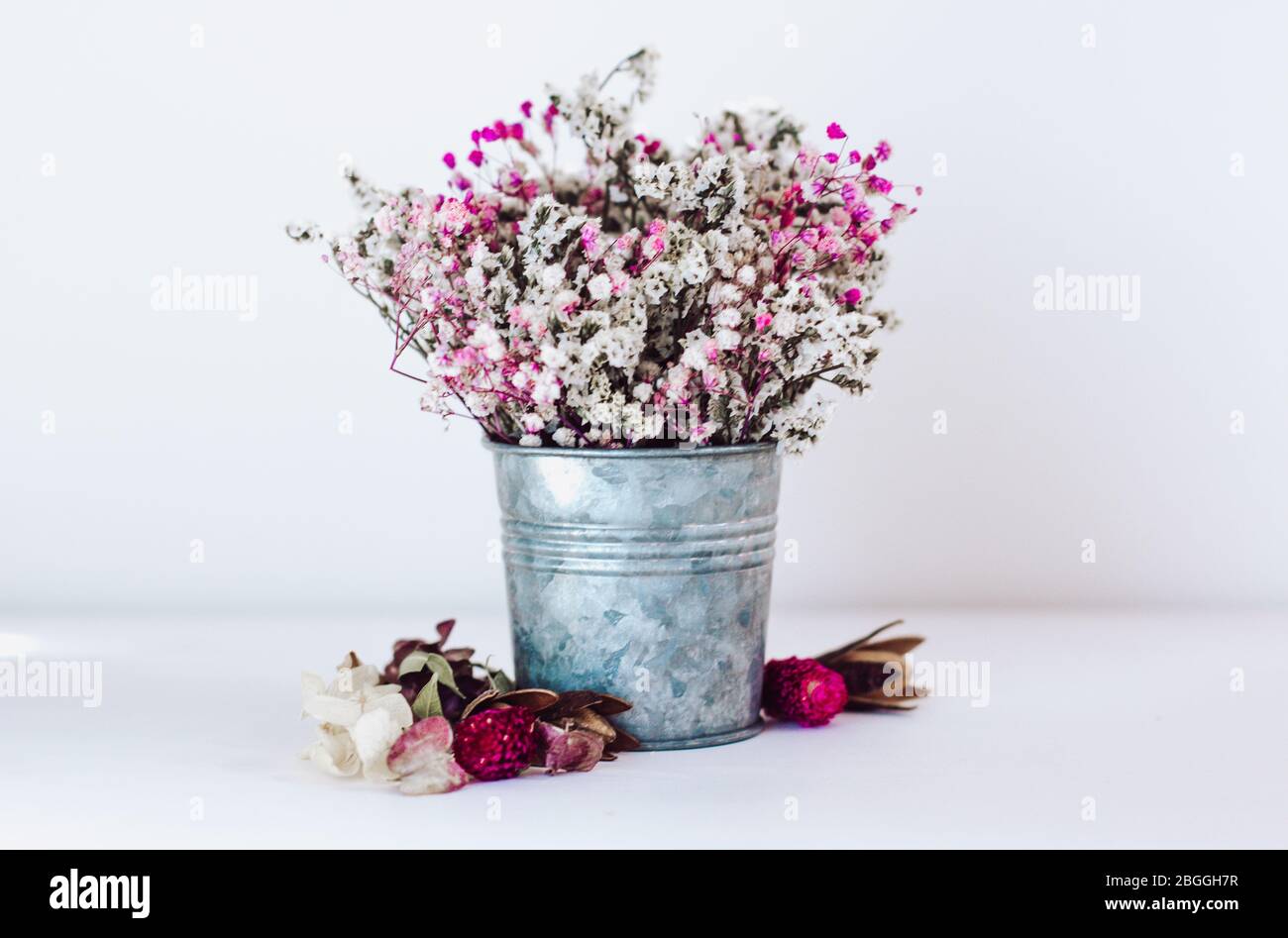 Getrocknete Blüten in einem rustikalen Eisenkeimer. Blume Komposition Boho Stil. Stockfoto
