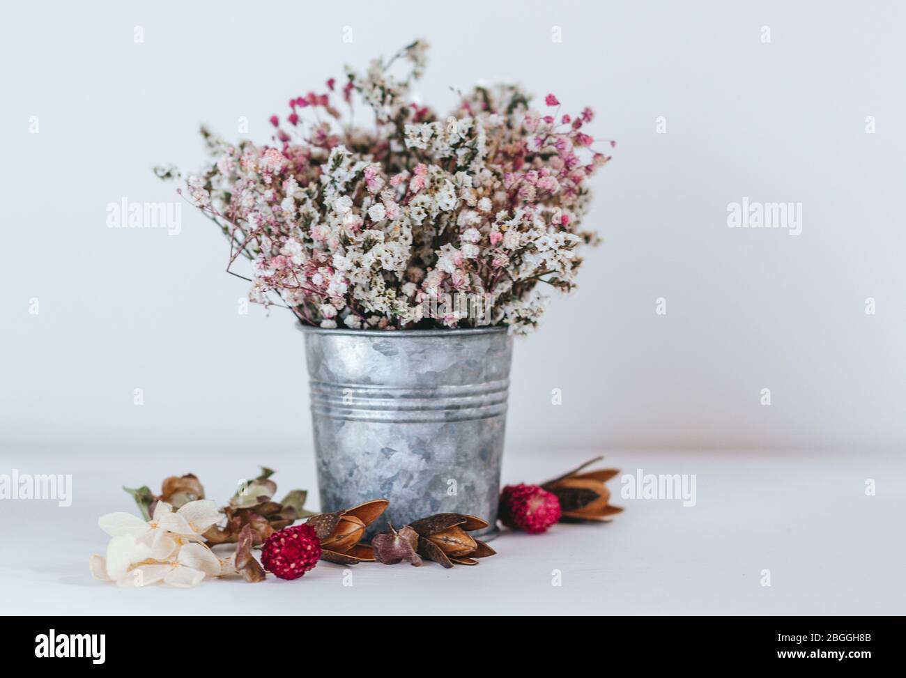 Getrocknete Blüten in einem rustikalen Eisenkeimer. Blume Komposition Boho Stil. Stockfoto