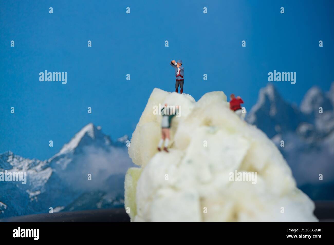 Kleine Leute, die einen Berggipfel aus gefrorenem Kohl besteigen Stockfoto