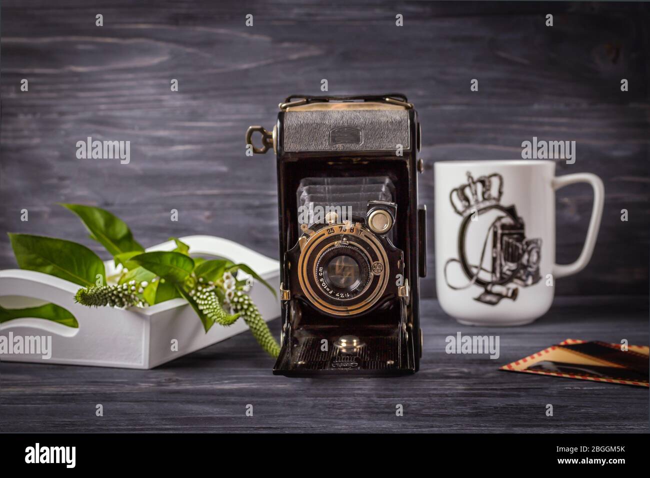 Krakau, Polen. Jule 15, 2017. Vintage Kamera, Tasse und Blumen. Das Konzept des Fotografentags Stockfoto