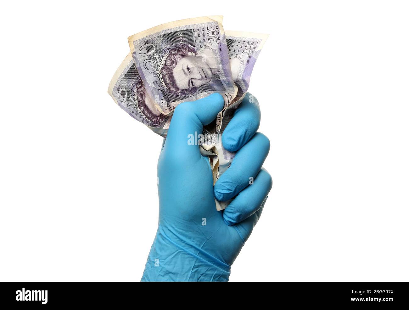 Covid 19 Finanzkonzept Bild eines Mannes in einem chirurgischen Gummihandschuh mit UK 20 Pfund Noten als Coronavirus zerdrückt die Wirtschaft Stockfoto