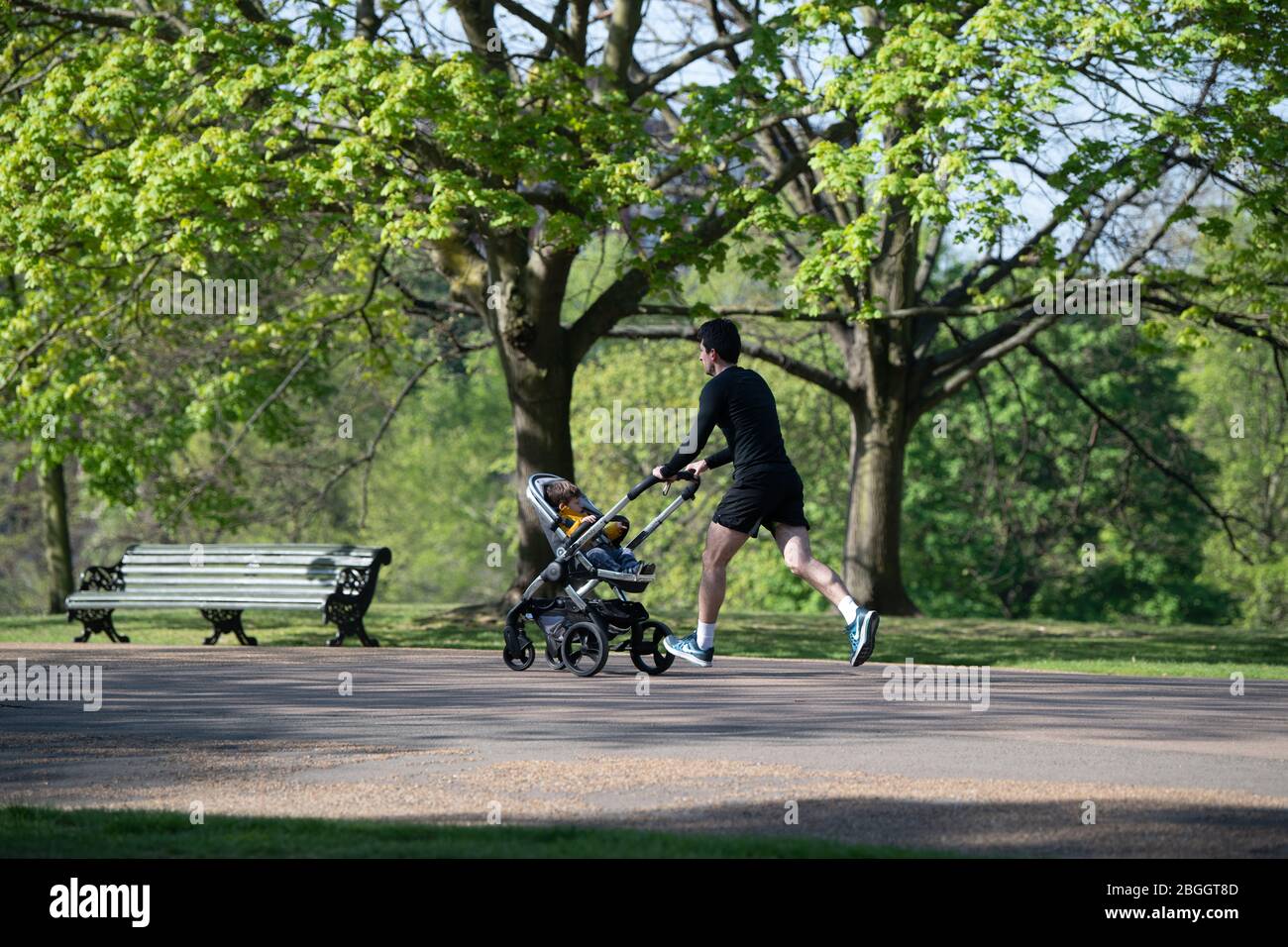Mann, der mit einem Kinderwagen in Kensington Gardens während der Lockdown in London, Großbritannien, läuft, wo eine Outdoor-Übung pro Tag erlaubt ist. Stockfoto