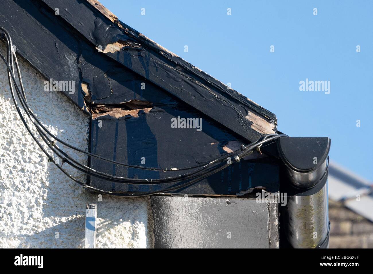 Verfaulte hölzerne eves, soffit Boards und Barge Boards auf Haus, zusammen mit schlechten Himmel Satelliten-Verdrahtung Installation - UK Stockfoto