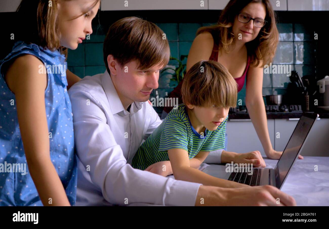 Nette Kinder verwenden Laptop für Bildung, Online-Studie. Junge und Mädchen haben Hausaufgaben im Fernunterricht. Lifestyle-Konzept für Familie Quarantäne covid-19. Vater hilft Sohn. Stockfoto