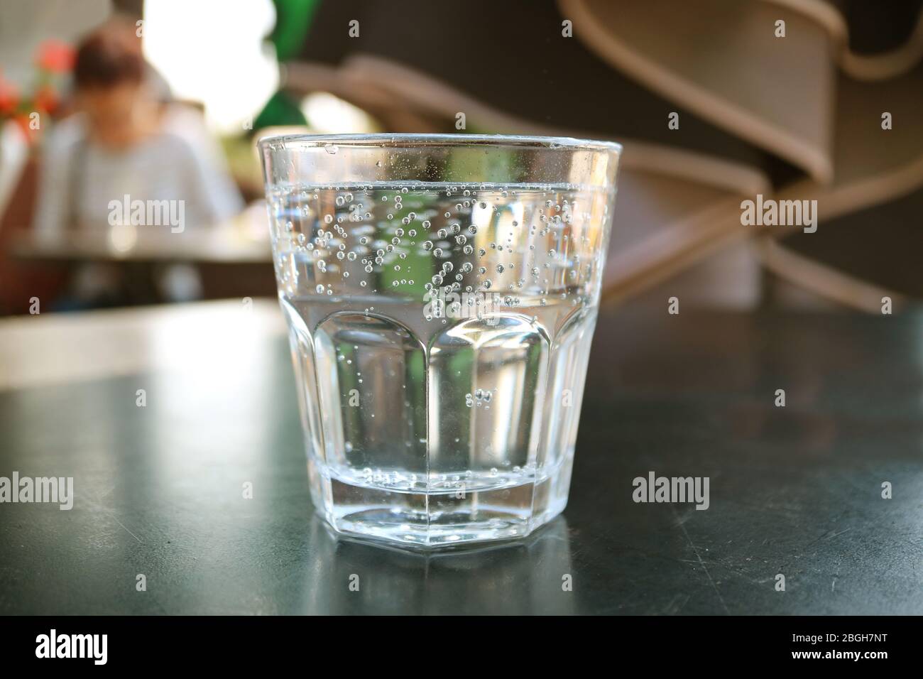 Ein Glas Mineralwasser auf schwarzem Tisch isoliert Stockfoto