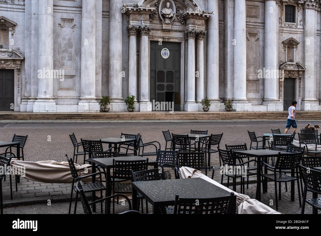 Das Bild zeigt menschenleere Tische und Stühle vor der Neuen Kathedrale auf dem Paul VI. Platz (Brescia, Italien). Stockfoto