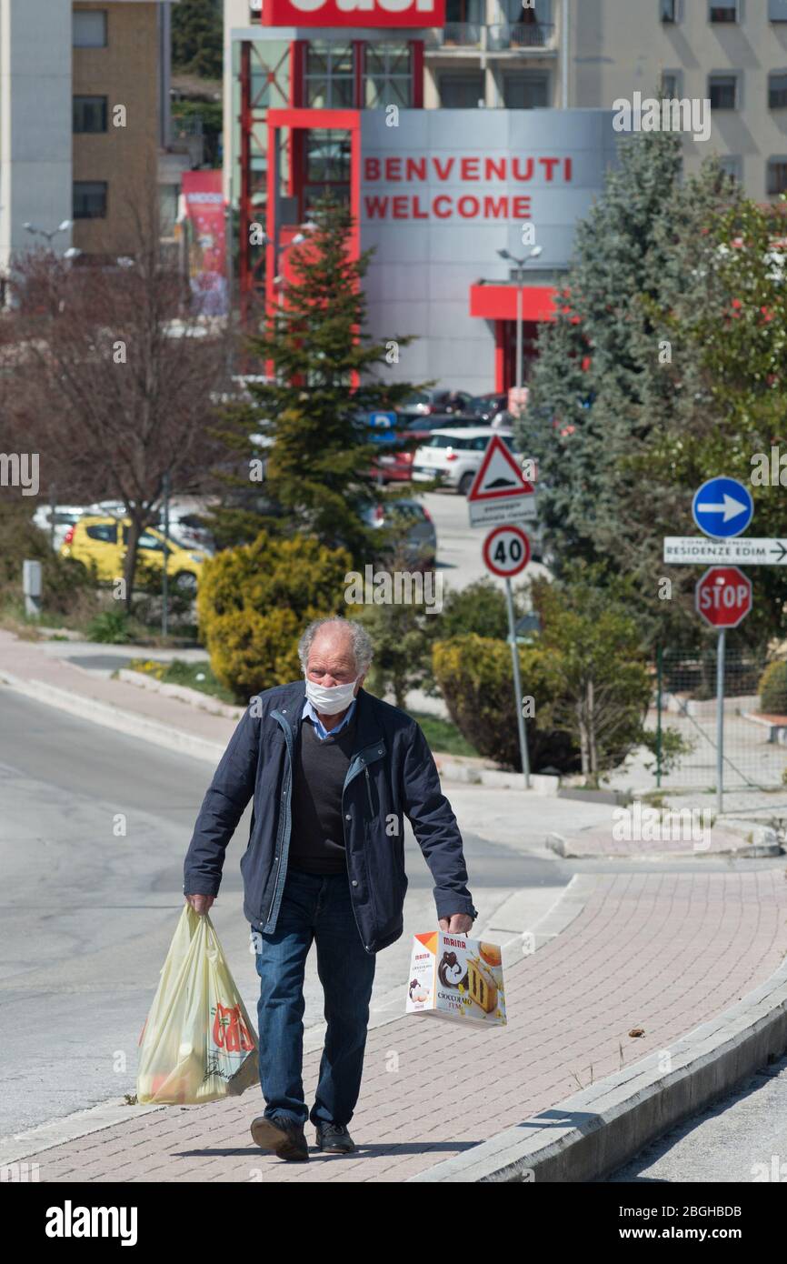 Campobasso, Molise Region, Italien: Ein älterer Mensch, mit Schutzmaske, kehrt nach dem Einkauf im Supermarkt während des Coronavirus Emerg nach Hause zurück Stockfoto