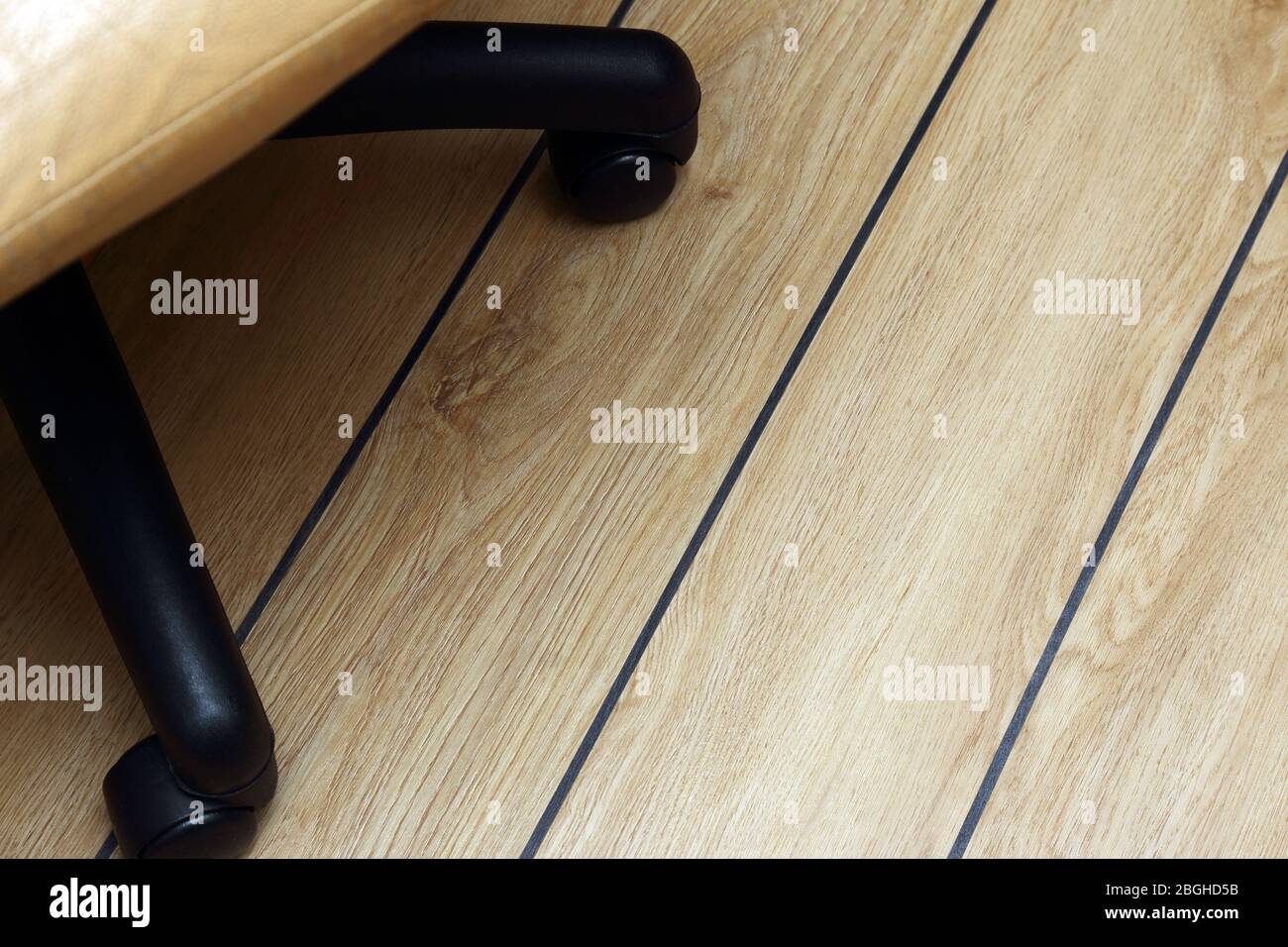 Bürostuhl, auf dem Parkettboden mit schwarzen Nähten Stockfoto