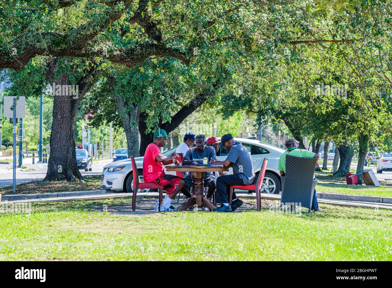 Senioren spielen Dominos auf der Median der Galvez Street in Mid City, New Orleans, Louisiana, USA Stockfoto