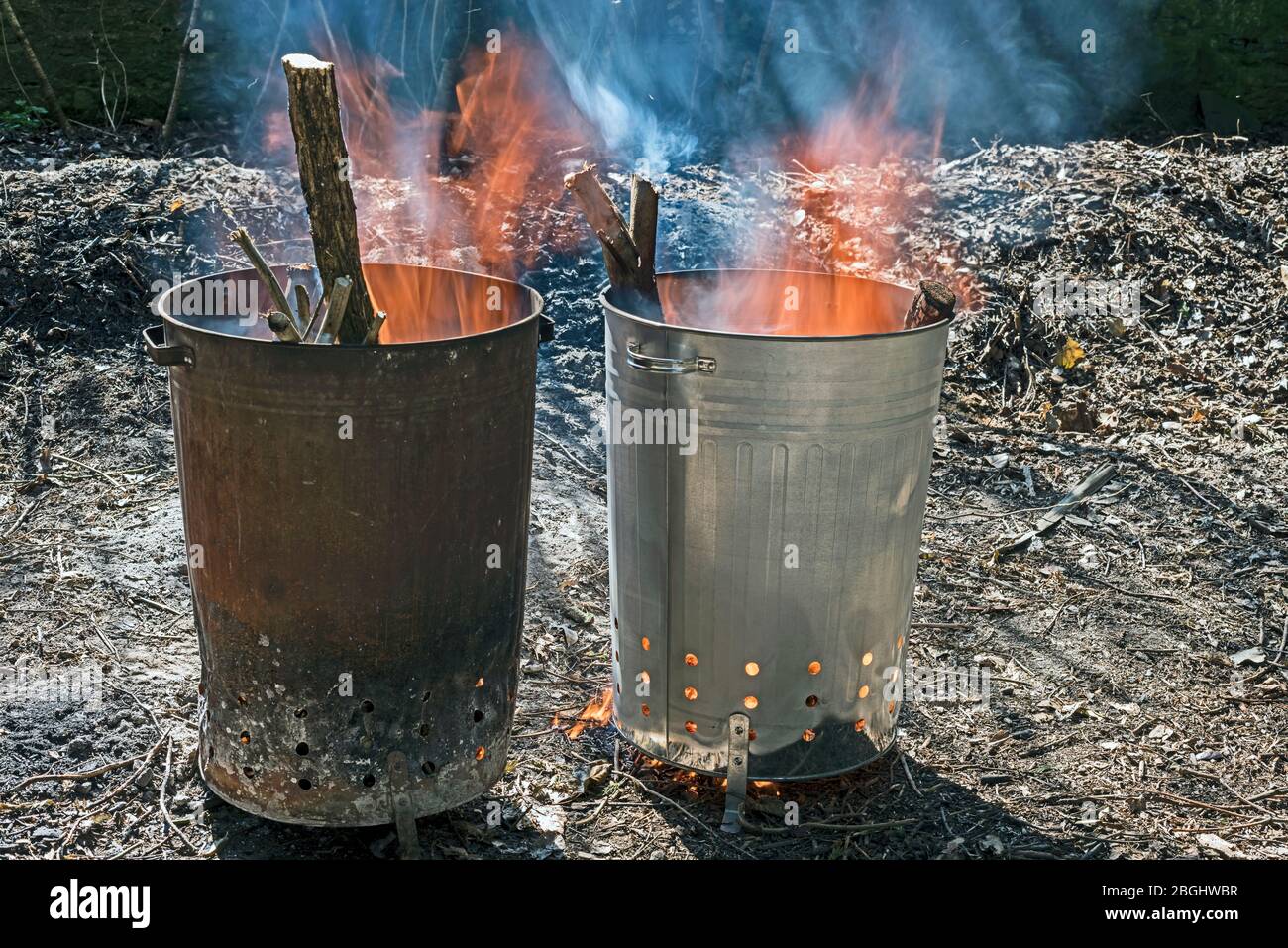 Zwei MetallGartenverbrennungsanlagen, die Holz verbrennen, eine alte