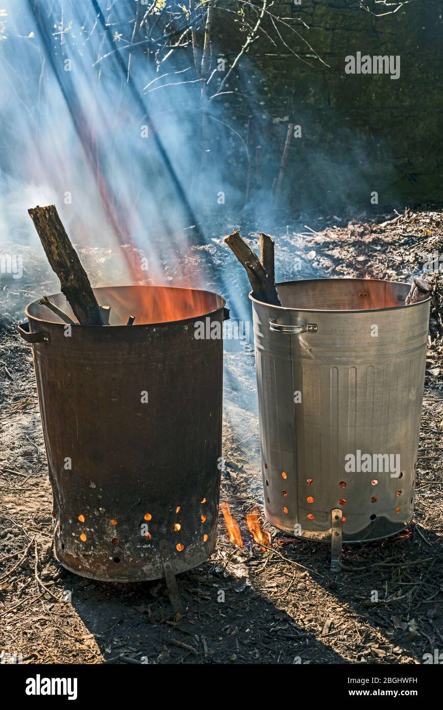 Zwei MetallGartenverbrennungsanlagen, die Holz verbrennen, eine alte