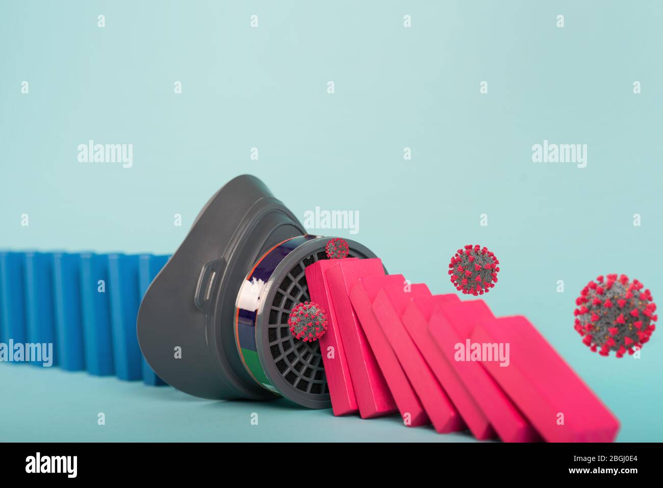 Konzept der covid19 Coronavirus Pandemie mit fallenden Kette wie ein Domino-Spiel. Ansteckung und Infektionsverlauf durch eine Maske gestoppt. Cyanfarbener Hintergrund Stockfoto