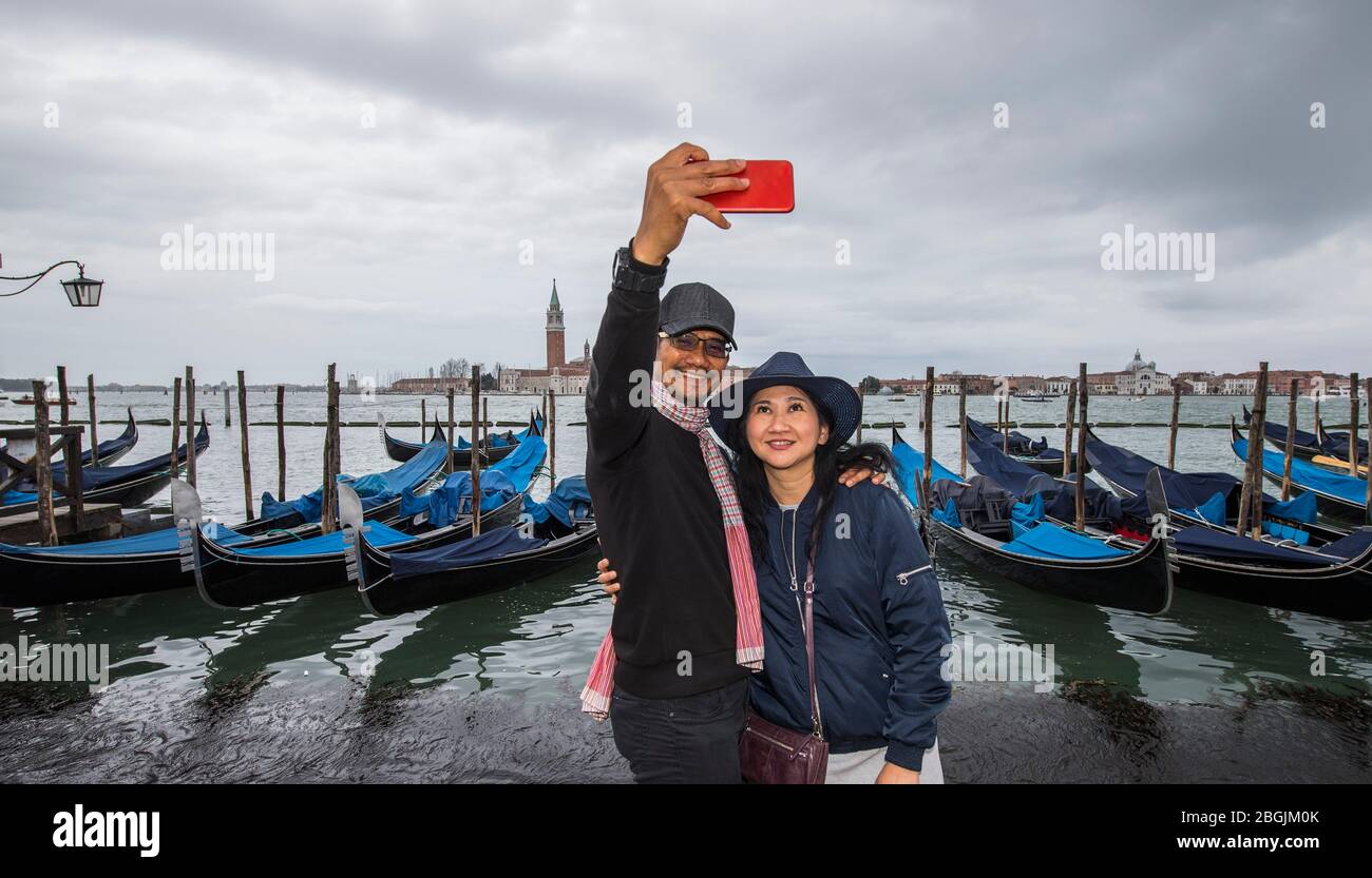 Thailändisches Paar beim Selfie vor der geparkten Gondel in Venedig Stockfoto