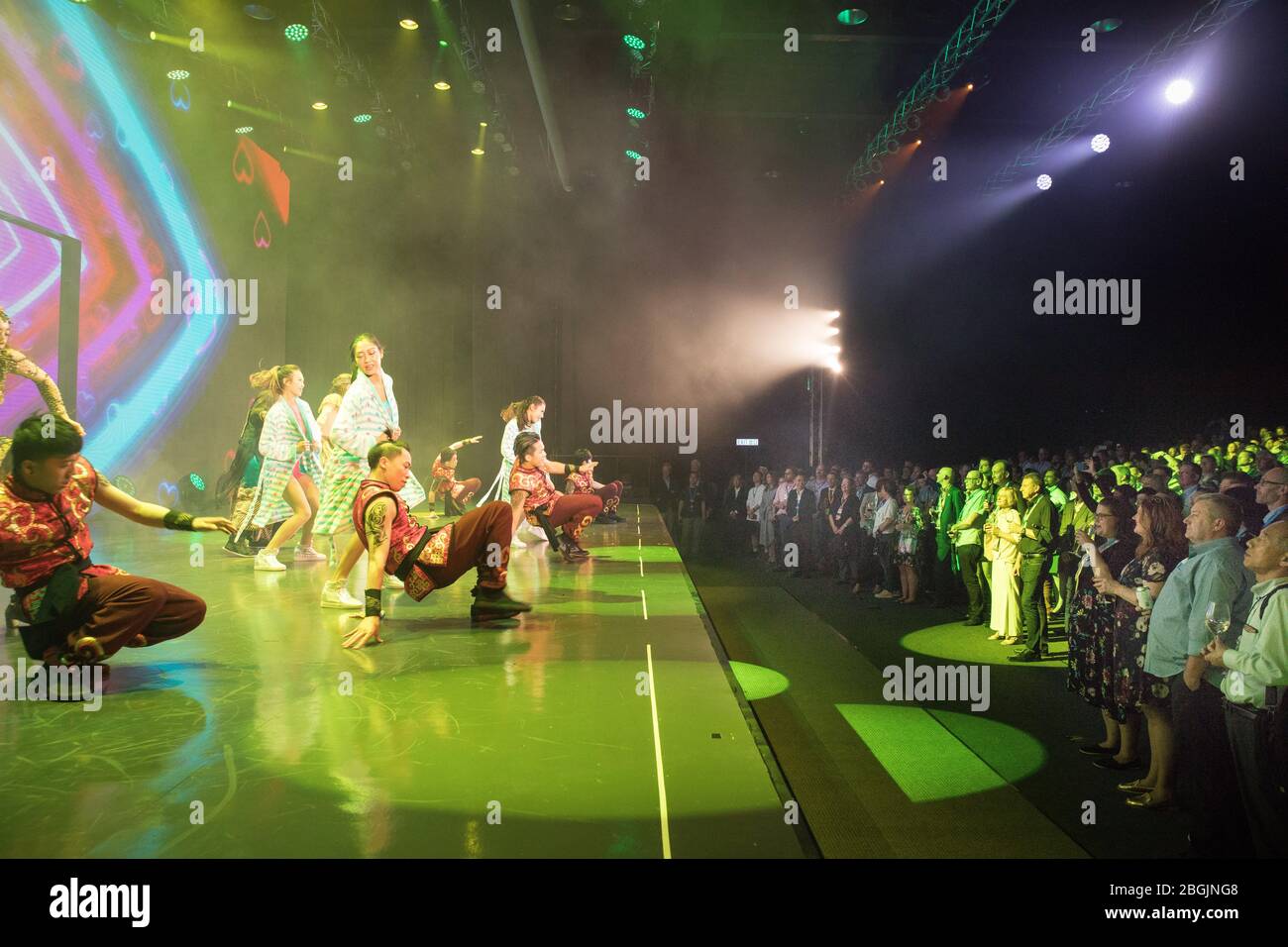 Chinesische Tänzer treten auf der Bühne auf, während eine große Menge anschaut Stockfoto