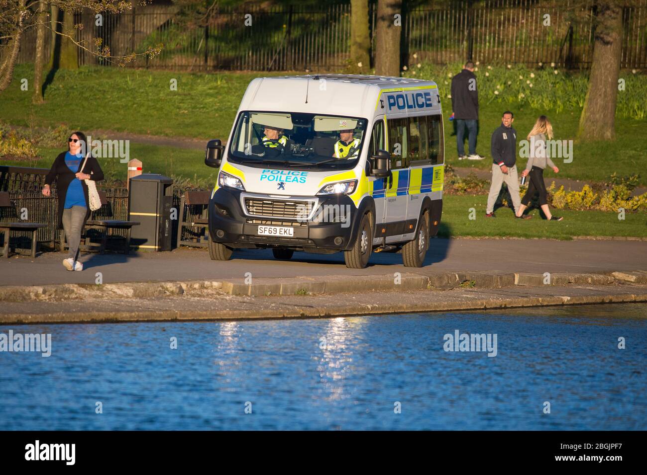 Glasgow, Großbritannien. April 2020. Bild: Ein Polizeiwagen fährt langsam durch den Park, beobachtet die Menschen, um sicherzustellen, dass sie sich sozial distanzieren und sorgt dafür, dass die Menschen nicht im Park herumlungern, da jeder während der Coronavirus (COVID-19) Lockdown eine Stunde Bewegung pro Tag zugeteilt wird. Quelle: Colin Fisher/Alamy Live News Stockfoto