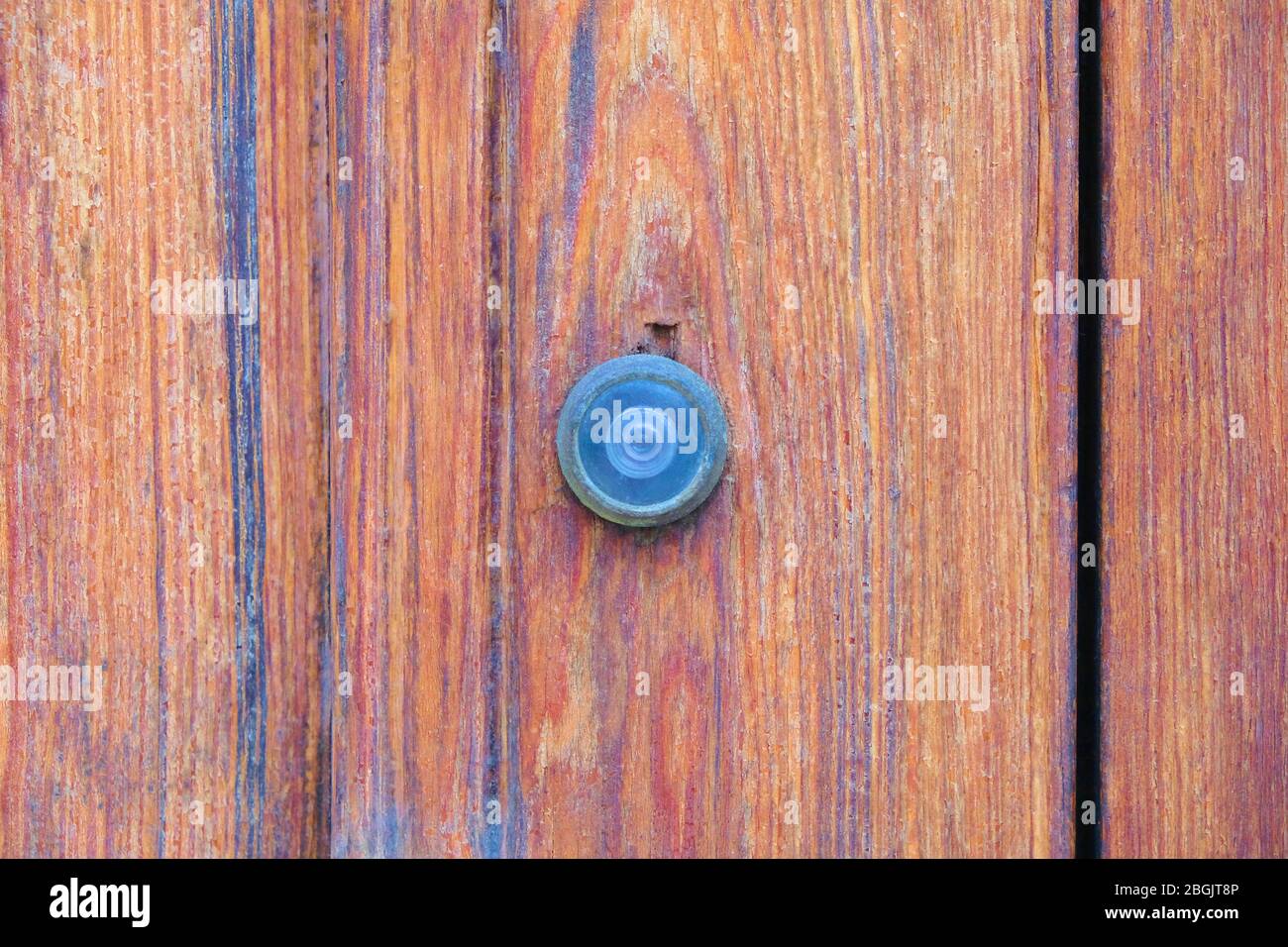 Ein Guckloch in der lackierten Holztür. Stockfoto