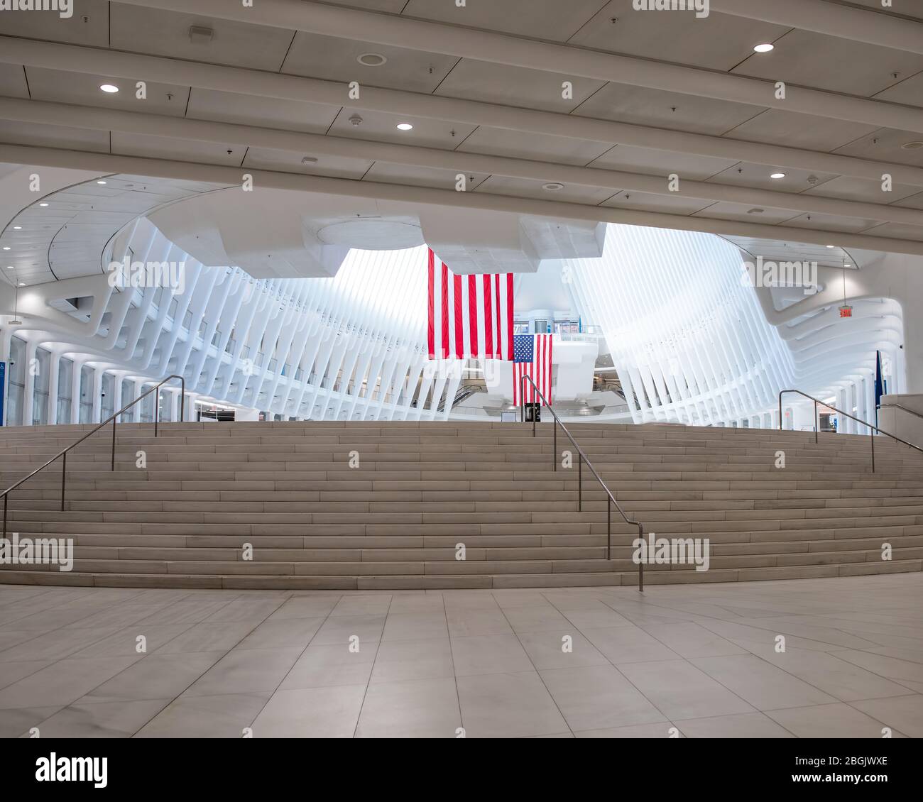 Oculus-Interieur im World Trade Center mit amerikanischer Flagge und Treppe im Vordergrund mit markingj weißen vertikalen Linien im Hintergrund. Stockfoto