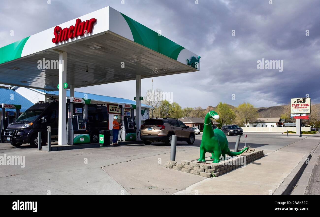 Ein Dinosaurier der Sinclair-Tankstelle mit Covid-19 Maske Stockfoto