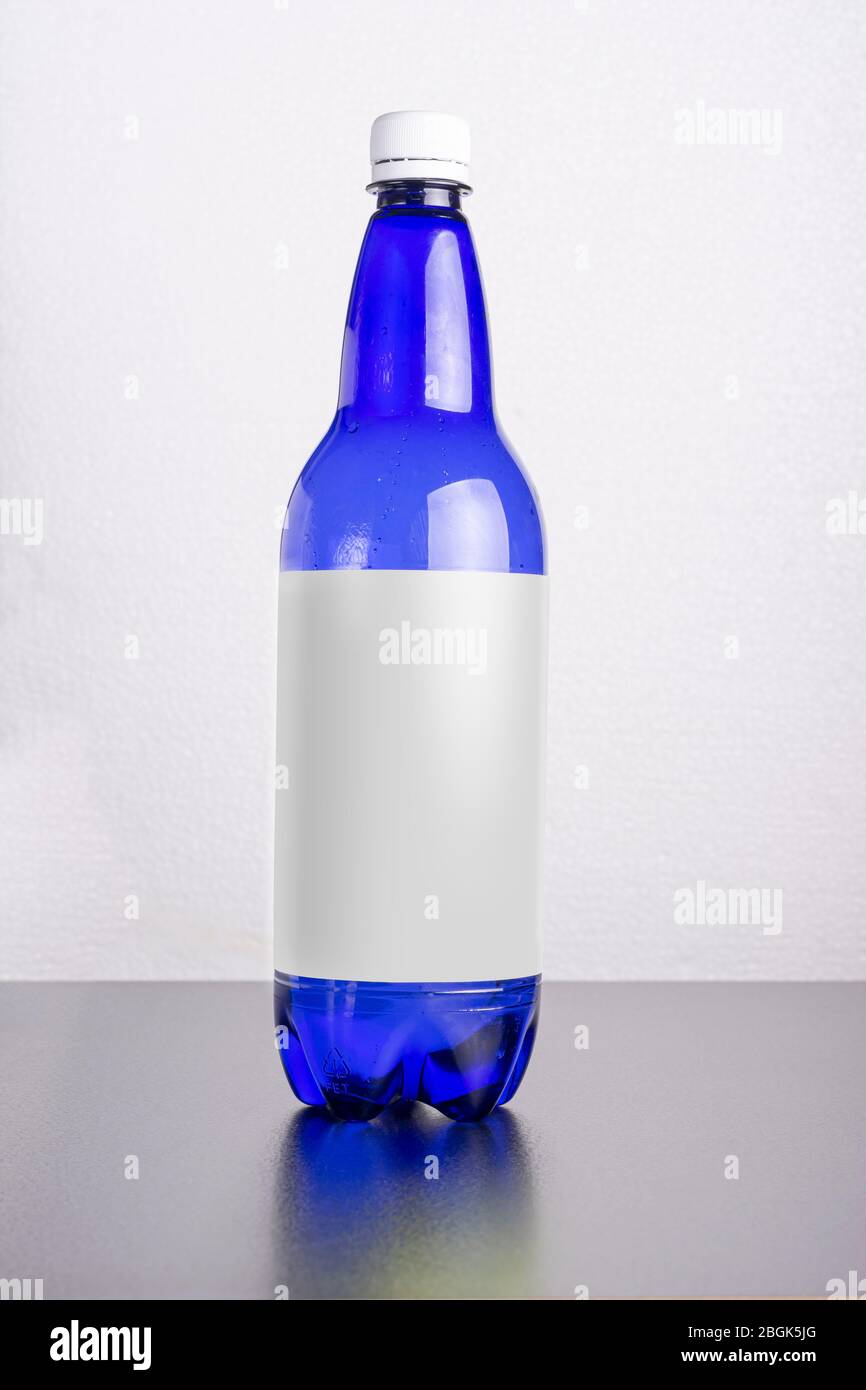 Blaue Flasche mit Etikett auf der Tischoberfläche, editierbare Smart Object Layer sind bereit für Ihr Design Stockfoto