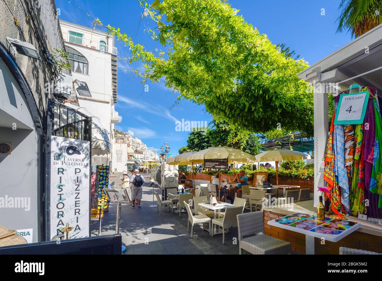 Ein kleines Café am Meer und Geschäfte unter einem Efeu Baldachin an der Amalfi Küste in der Stadt Amalfi, Italien. Stockfoto