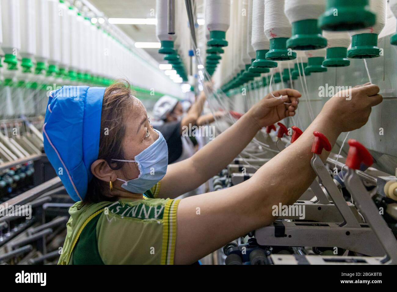 Die Mitarbeiter einer lokalen Spinnerei arbeiten entlang automatisierter Produktionslinien, um Aufträge rechtzeitig zu fertigen, im Bezirk Hai'an auf Kreisebene, Nantong c Stockfoto