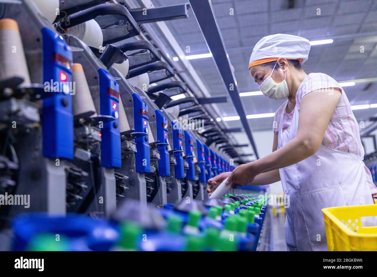 Die Mitarbeiter einer lokalen Spinnerei arbeiten entlang automatisierter Produktionslinien, um Aufträge rechtzeitig zu fertigen, im Bezirk Hai'an auf Kreisebene, Nantong c Stockfoto