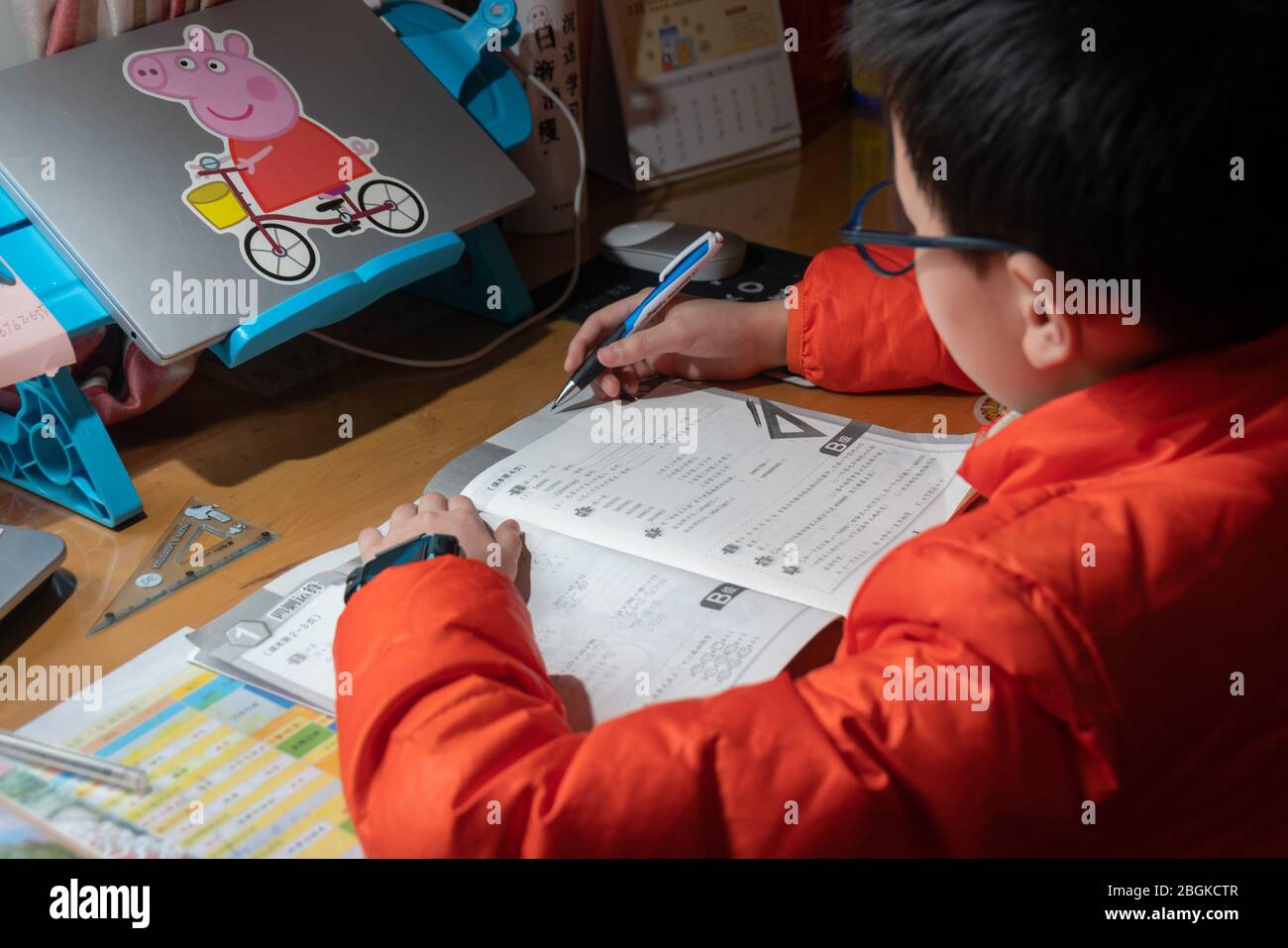 Ein Grundschüler macht Hausaufgaben, während er Unterricht über das Internet nimmt und von zu Hause aus studiert, Shanghai, China, 3. März 2020. *** Ortsunterschrift *** Stockfoto