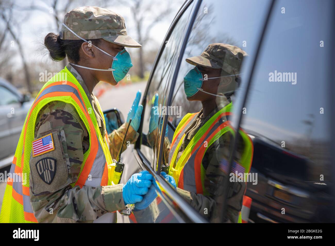 New York Army National Guard Spc. Gilliam-Grey Shawnese, die dem 101st Expeditionary Signal Battalion, 369th Sustainment Brigade, New York Army National Guard, zugewiesen ist, gibt Anweisungen an die Menschen in ihren Fahrzeugen im COVID-19 Mobile Testing Center in Glenn Island Park, New Rochelle, 8. April 2020. Die New York National Guard unterstützt weiterhin sieben Drive-Thru-Teststandorte. Soldaten und Luftwaffe sammeln Proben und bieten allgemeine Unterstützung an den Teststandorten an, die insgesamt 5,000 Tests pro Tag übersteigen. (USA Foto der Armee-Nationalgarde von Sgt. Jonathan Pietrantoni) Stockfoto