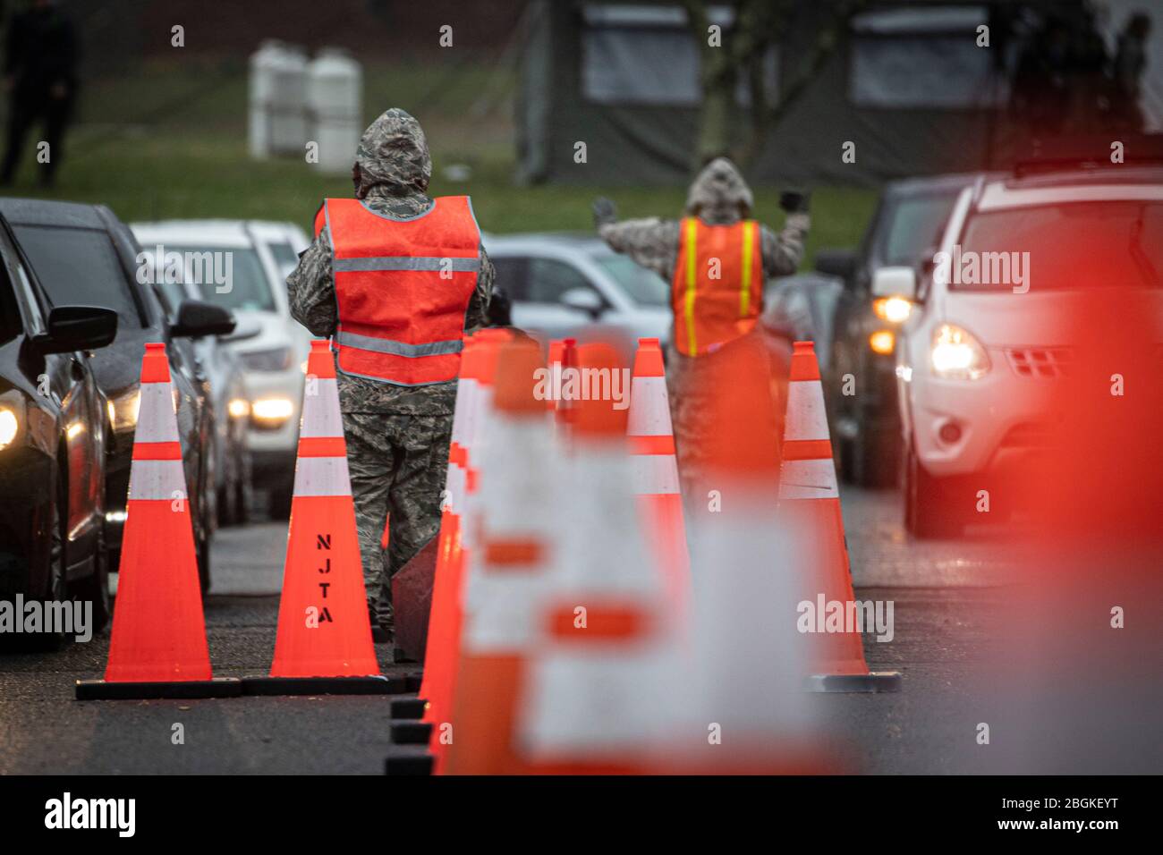 New Jersey Air Guard Airmen aus dem 108. Flügel sorgen für Verkehrskontrolle an einem COVID-19 Community-based Testing Site im PNC Bank Arts Centre in Holmdel, N.J., 23. März 2020. Die Teststelle, die in Zusammenarbeit mit der Federal Emergency Management Agency gegründet wurde, wird vom New Jersey Department of Health, der New Jersey State Police und der New Jersey National Guard besetzt. (USA Foto der Air National Guard von Meister Sgt. Matt Hecht) Stockfoto
