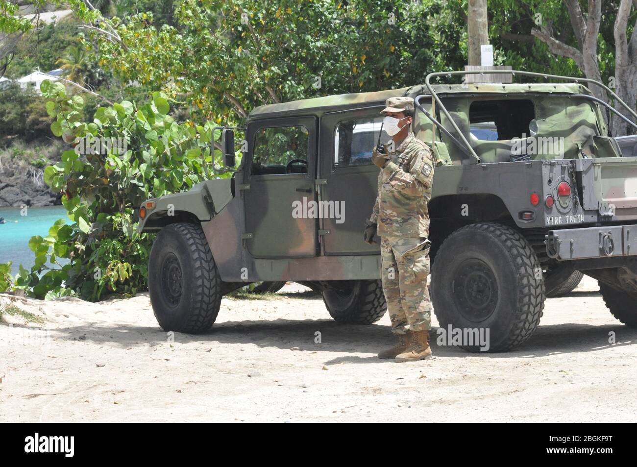 Cadet Josinio Andrew kommuniziert auf einem Handfunkgerät am Hull Bay Beach, St. Thomas, 18. April 2020. Mitglieder des 786. Bataillons zur Unterstützung der Nachhaltigkeit im Kampf unterstützen das VI. Gesundheitsministerium bei der Aufklärung der Ankündigung des öffentlichen Dienstes, die Ausbreitung der COVID-19-Pandemie zu verlangsamen. Stockfoto