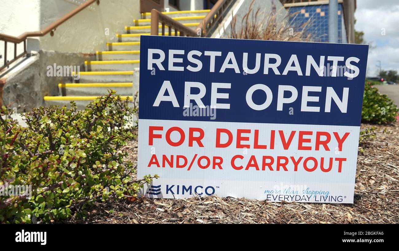 Ein Schild am Eingang zu einem Einkaufsviertel erinnert die Leute daran, dass Restaurants noch offen sind, um zum Mitnehmen. Stockfoto