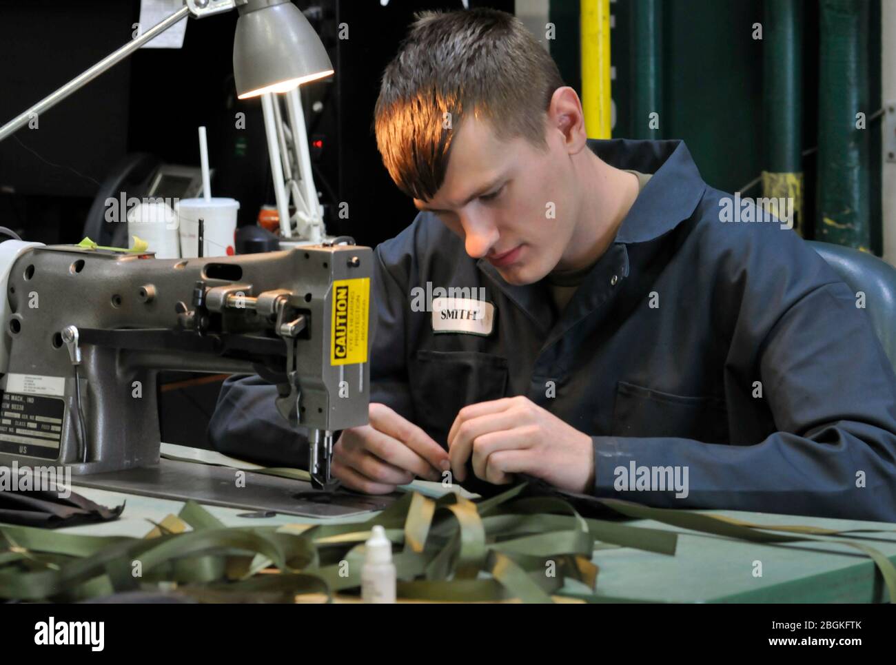 Soldaten der Oregon Army National Guard der Alliierten Handelsabteilung arbeiten hart daran, persönliche Schutzausrüstung (PSA) zu erstellen, um die Bedürfnisse der anderen Gardisten während des Ausbruchs der COVID-19 am 7. April 2020 im Lager Withycombe in Clackamas, Oregon, zu unterstützen. Die Teams arbeiten normalerweise an Reparaturteilen wie Sitzbezügen und Zelten, stellen aber 1,000 Masken und 1,000 Gesichtsschutzscheiben her, um die Verwendung von PSA aus dem nationalen Notvorrat zu vermeiden. (Foto der Nationalgarde von John Hughel, Oregon Military Department Public Affairs) Stockfoto