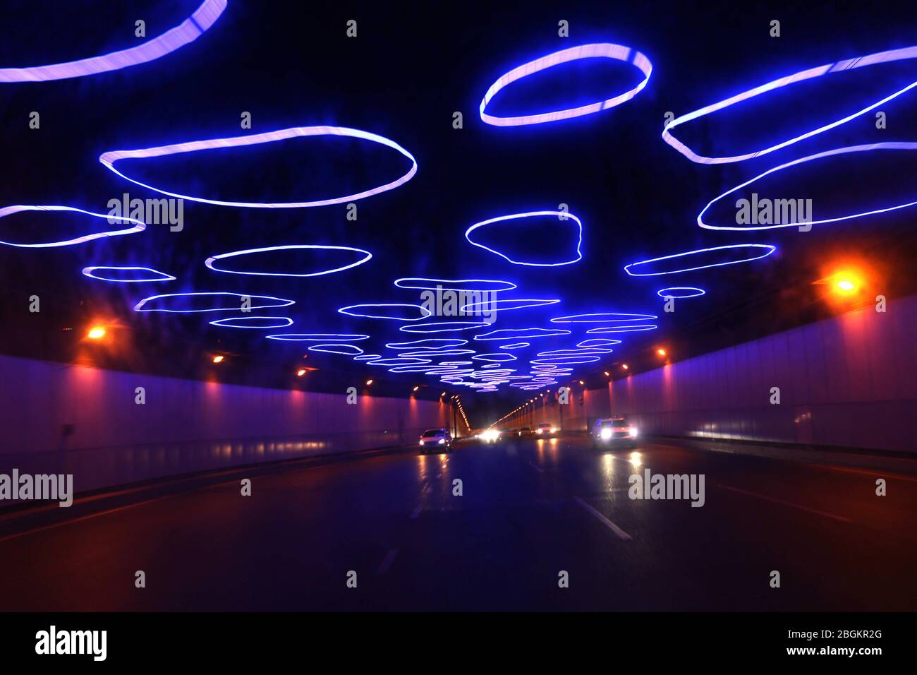 Fahrzeuge bewegen sich langsam in einem 3000 Meter langen Tunnel, in dem blaue LED-Lichtstreifen oben angebracht sind und daher den Spitznamen 'Zeittunnel' Chon trägt Stockfoto