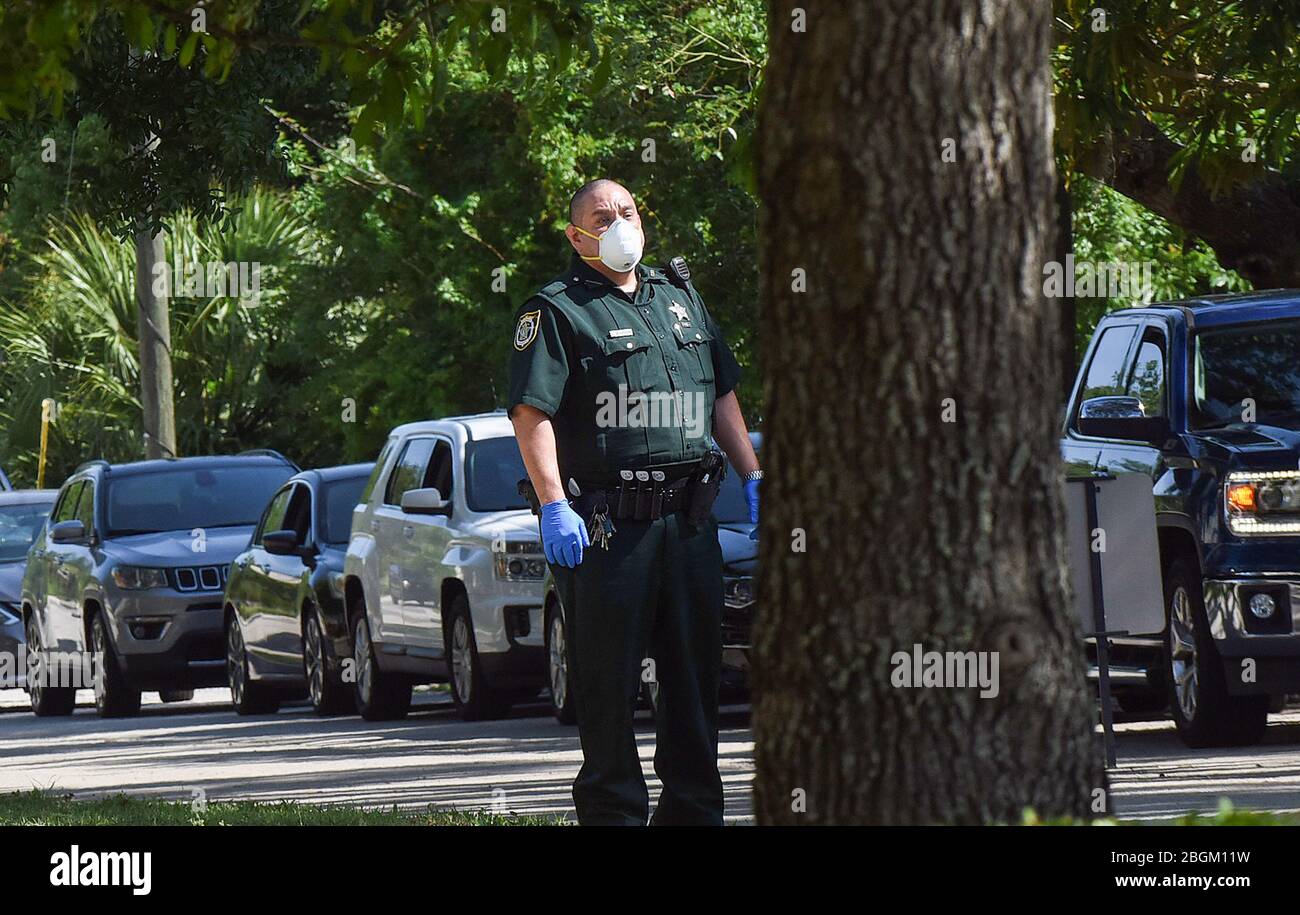 Altamonte Springs, Usa. April 2020. Ein stellvertretender Sheriff mit einer schützenden Gesichtsmaske leitet den Verkehr an einem mobilen Testgelände COVID-19 in der Apostolischen Kirche Christi in einem historischen schwarzen Viertel in Seminole County, Florida. Staatliche und County Gesundheitsbeamte bieten kostenlose Tests in sechs historischen schwarzen Nachbarschaften, um Bewohner zu helfen, die nicht in der Lage sind, zu einer Krankenstation fahren oder nicht in der Lage sein, Krankenversicherung leisten können. Quelle: SOPA Images Limited/Alamy Live News Stockfoto