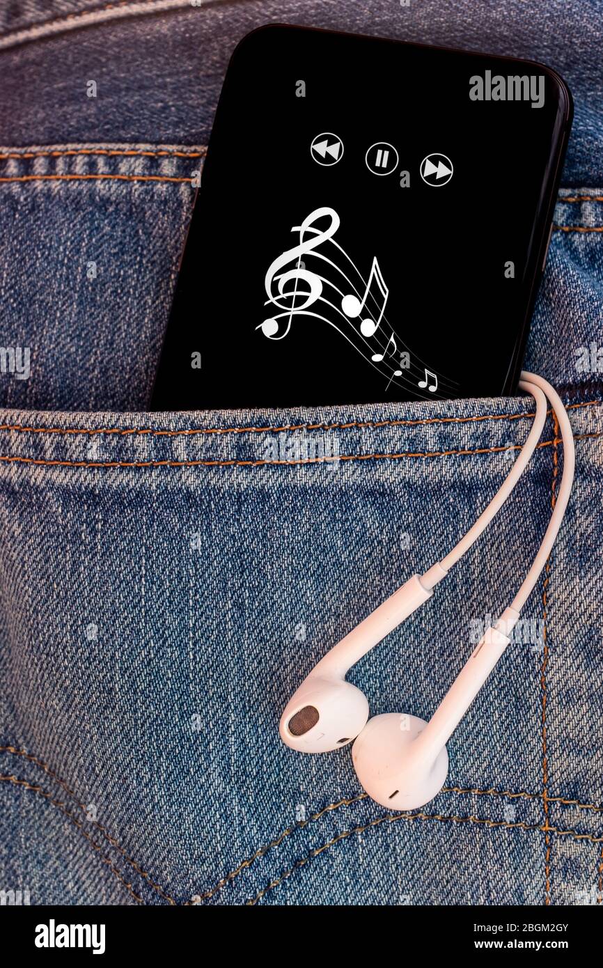 Schwarzes Smartphone mit Musiknoten in Jeans-Tasche. Stockfoto