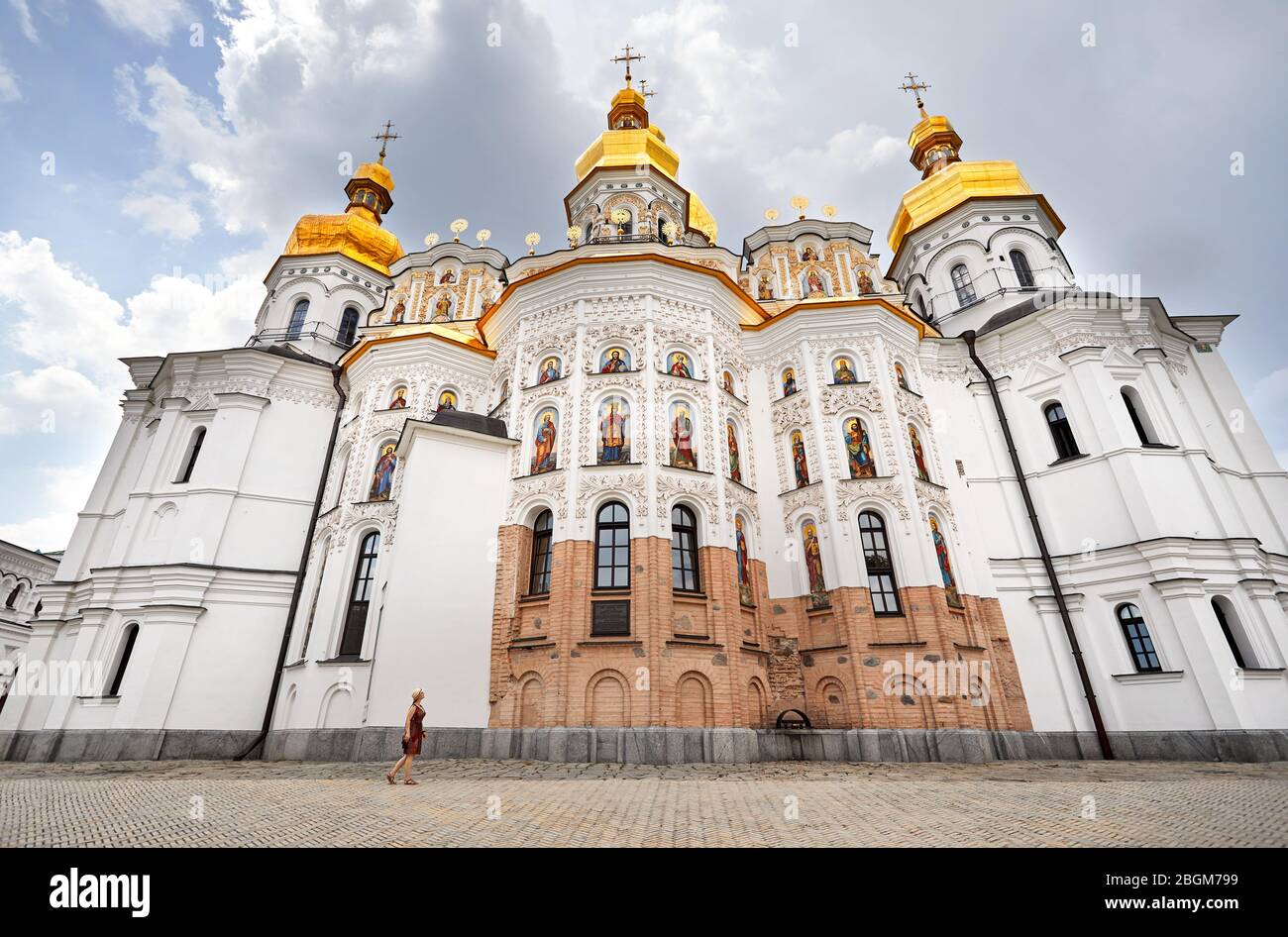 Frau in hat man in der Nähe der Kirche mit goldenen Kuppeln in Kiew Pechersk Lavra Christian komplex. Alte historische Architektur in Kiew, Ukraine Stockfoto