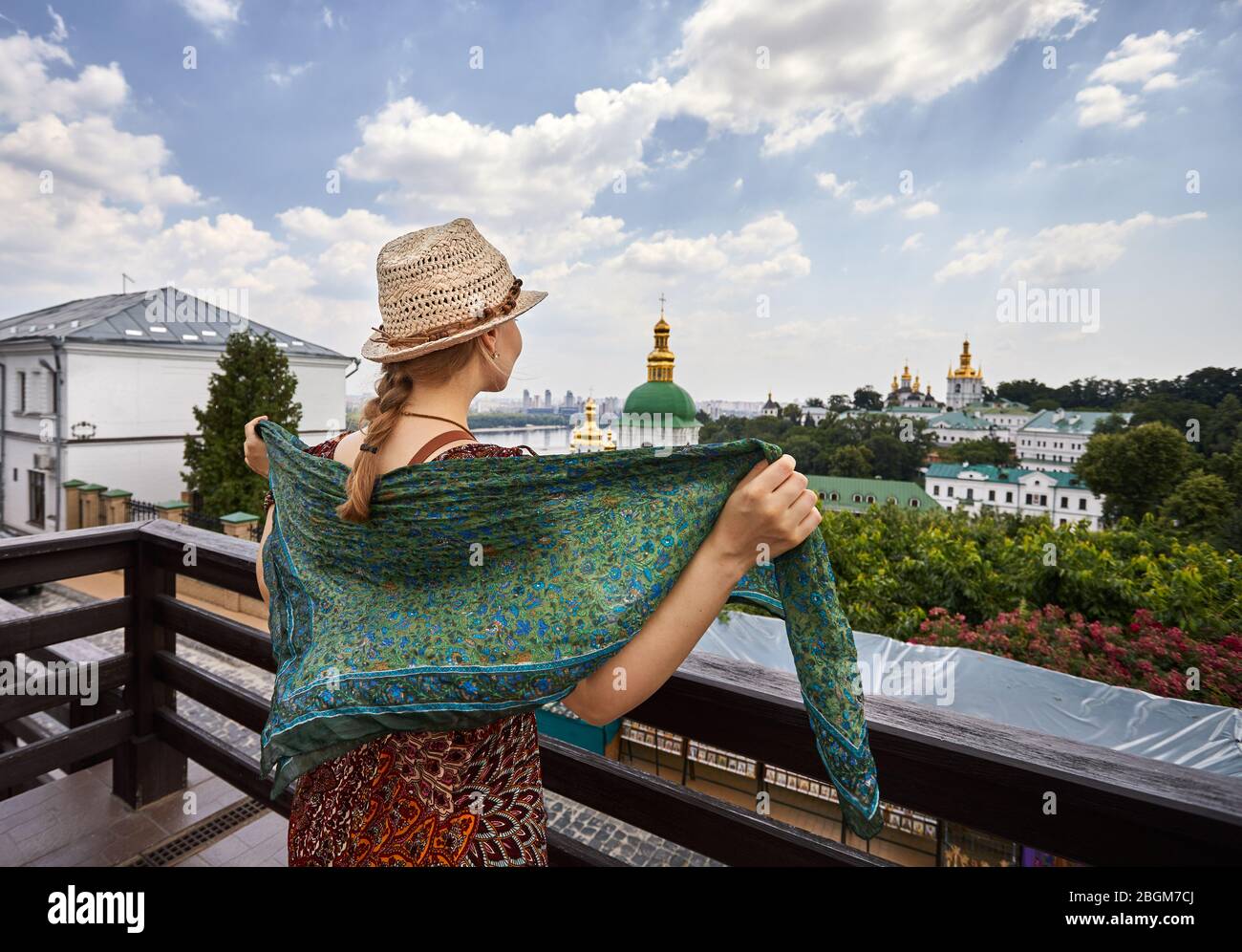 Frau mit Hut mit Schal mit Blick auf die Kirche mit goldenen Kuppeln in Kiew Pechersk Lavra Christian komplex. Alte historische Architektur in Kiew, Ukraine Stockfoto
