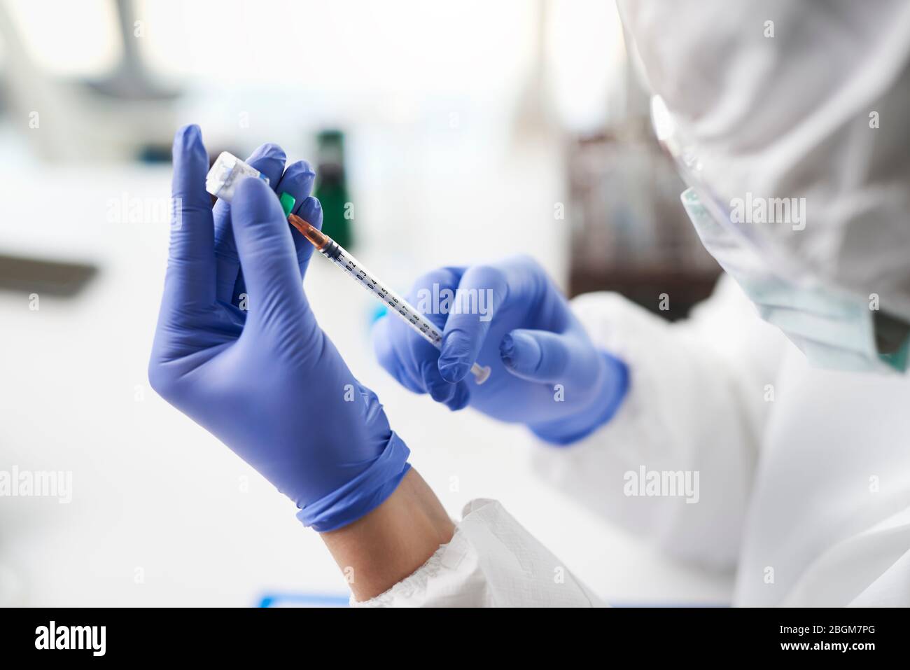 Menschliche Hände halten Coronavirus Medizin und eine Spritze Stockfoto